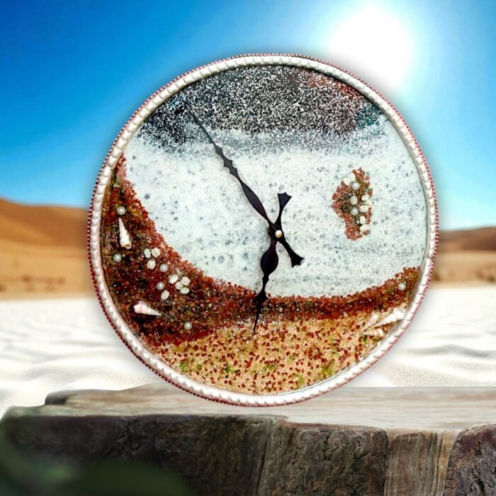 Moonlight Sea Beach Clock4 Detailed Design & Craftsmanship: Beach Landscape Dial: The clock face is a miniature artwork, designed to resemble a serene coastal scene with sandy layers, foamy waves, and sparkling moonlit textures. Textured Sand Effect: Realistic detailing in shades of sandy brown, beige, and terracotta gives the impression of a natural beach surface. Ocean Wave Layering: White resin waves merge into shimmering blue-gray tones, evoking the calmness of a sea under moonlight. Seashell & Pebble Accents: Embedded shells and stone-like textures add authenticity, making each clock one-of-a-kind. Elegant Black Hands: Contrasting black designer hands provide clear visibility while enhancing the artistic look. Premium Resin Finish: Gloss-coated for durability and a polished, luxurious feel.